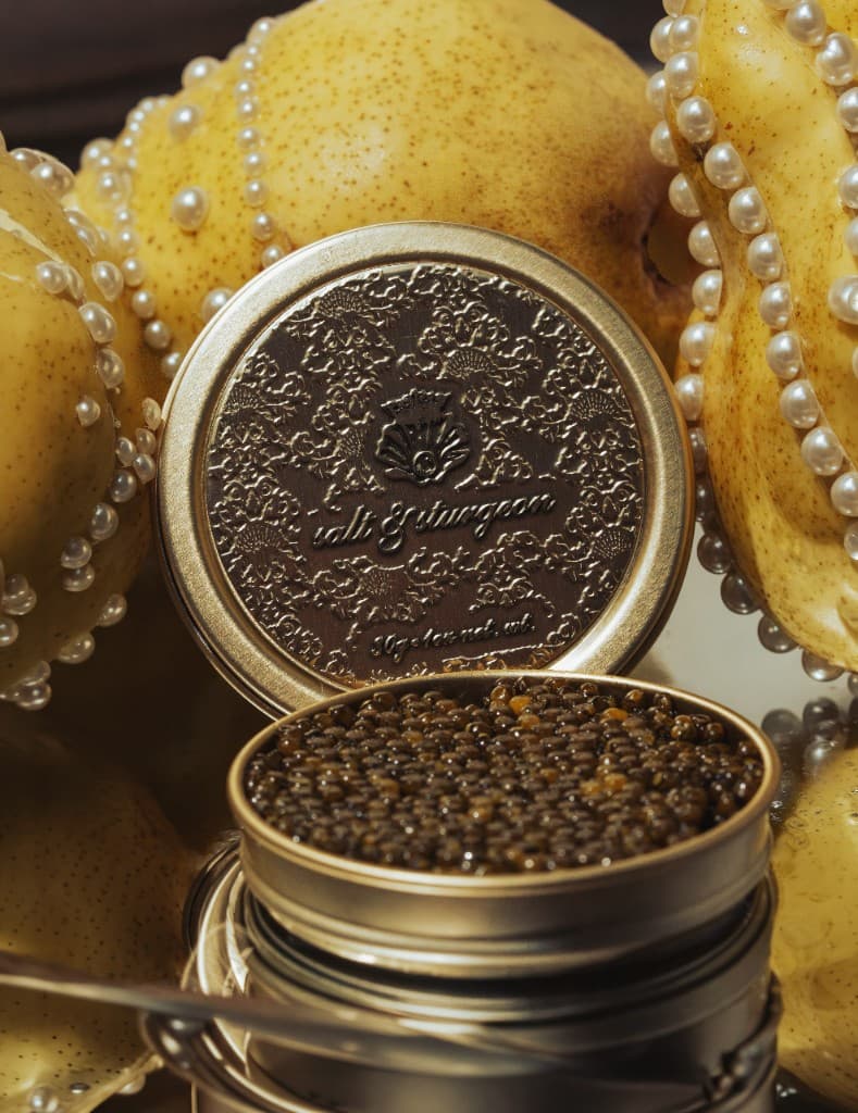 Open Salt & Sturgeon tin with the embossed lid, surrounded by pears and pearls